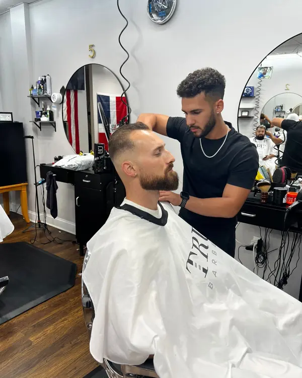 Barber finishing a client's haircut and beard